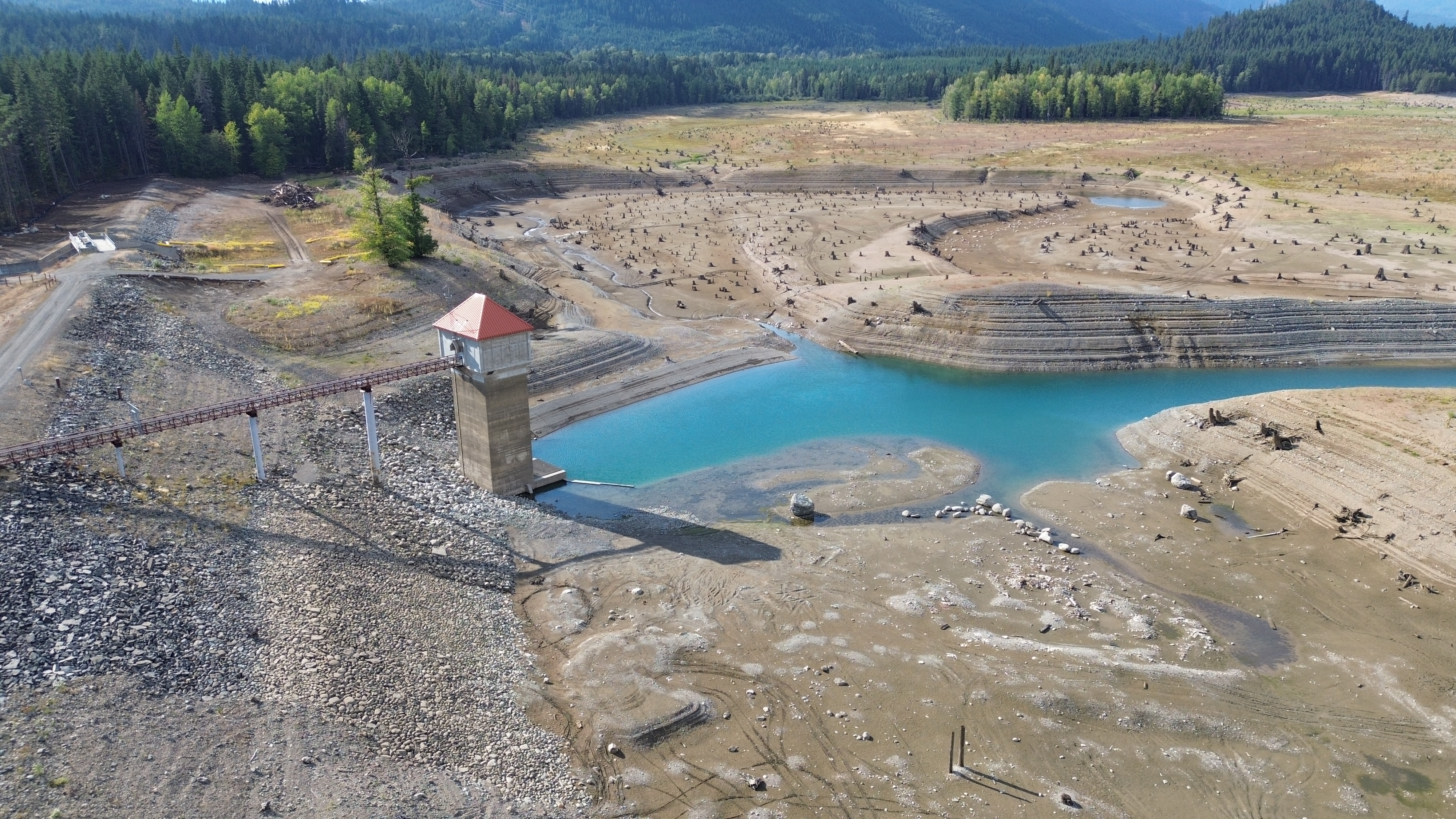 A reservoir, with only a narrow strip of water below the tower.